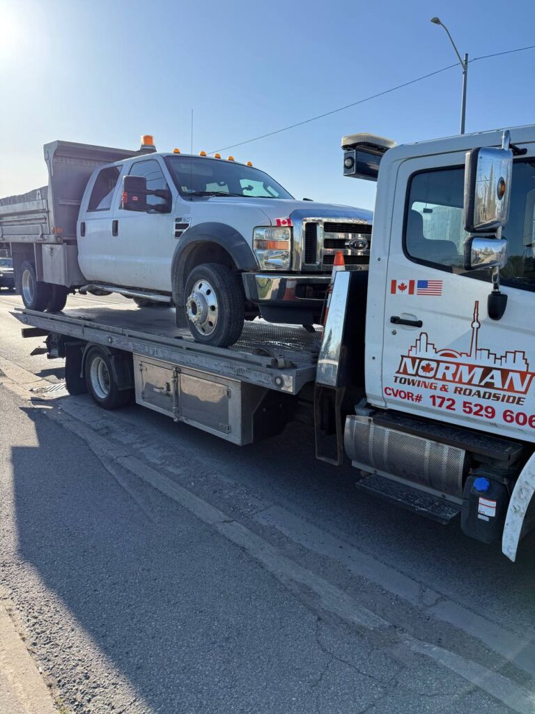 Commercial heavy-duty tow truck assisting large vehicle on roadside