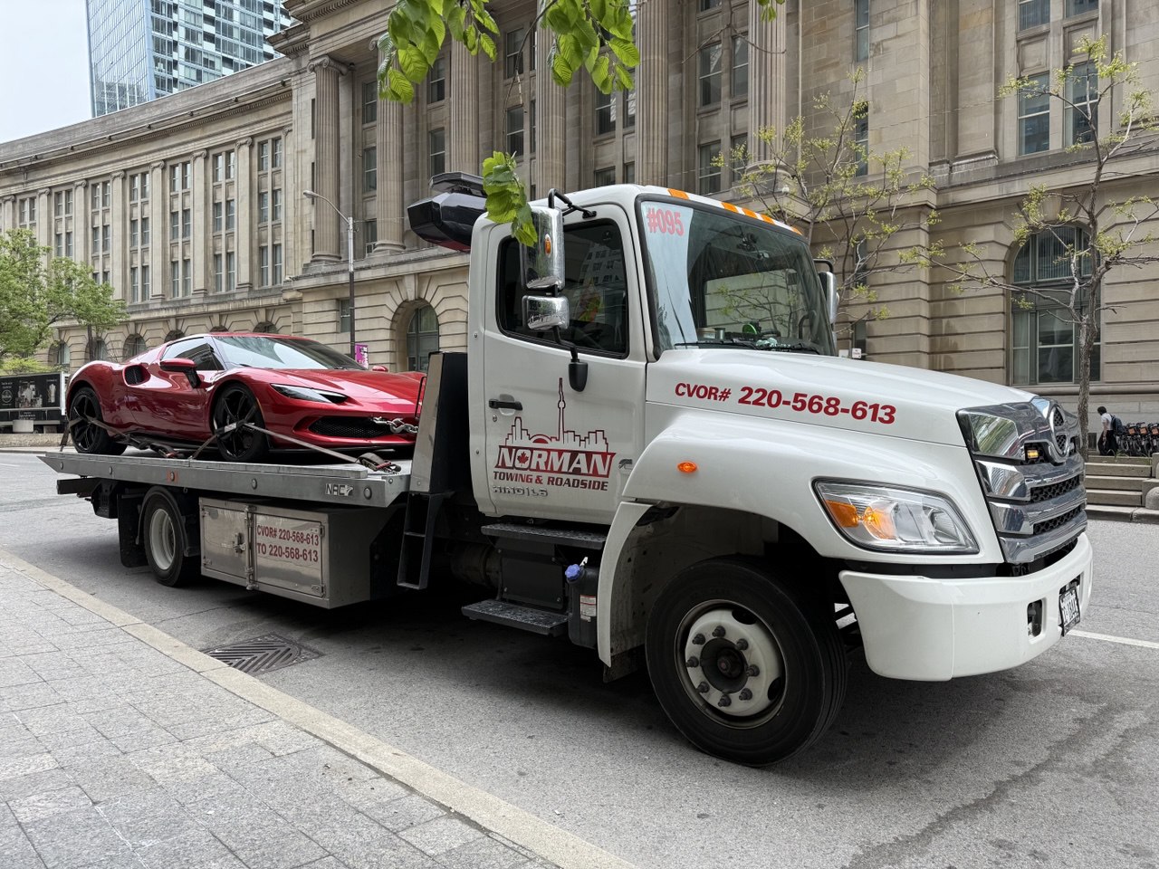 Flatbed tow truck transporting a car safely