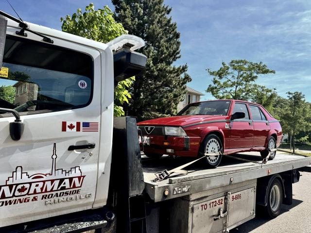 Red Alfa Romeo 75 on Norman Towing flatbed