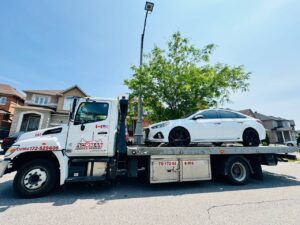 Tow truck removing unauthorized car in Mississauga private lot