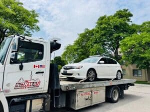 Tow truck towing a car from private property in Hamilton