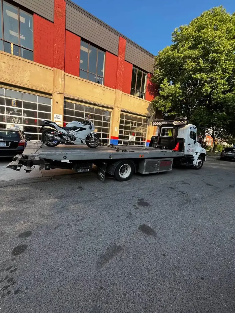 Towing a red sportbike with a flatbed tow truck