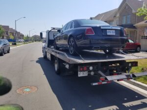 Tow truck removing a car from private property in Hamilton
