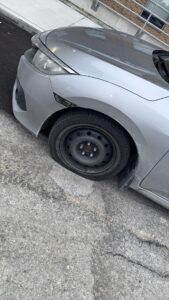 Close-up of a Toyota silver alloy wheel and all-season tire during a roadside service check in Toronto.